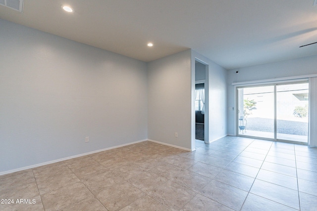 tiled spare room featuring ceiling fan