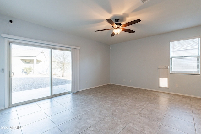 tiled spare room featuring ceiling fan and a wealth of natural light