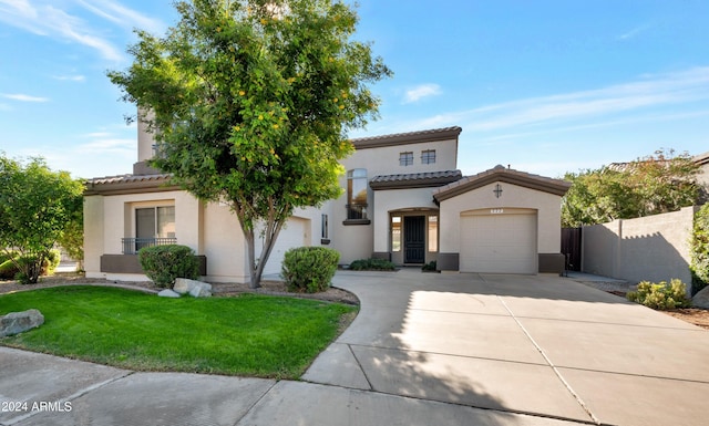 mediterranean / spanish home with a front lawn and a garage