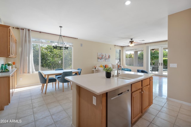 kitchen featuring a wealth of natural light, a kitchen island with sink, sink, and stainless steel dishwasher