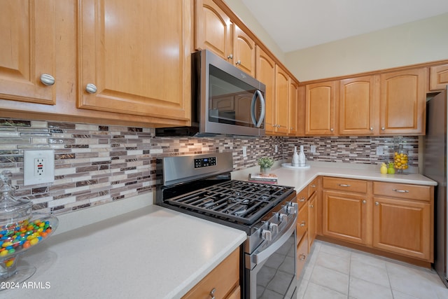 kitchen with decorative backsplash, light tile patterned floors, and stainless steel appliances