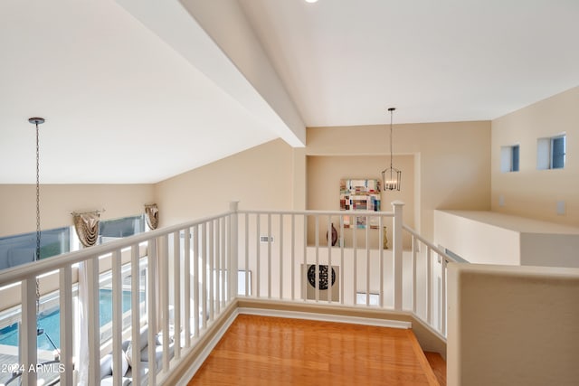 hall featuring lofted ceiling with beams and a chandelier