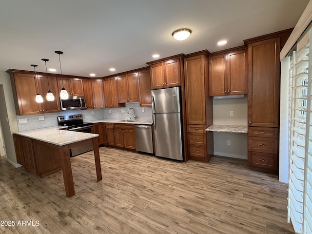 5525 E Thomas Rd Unit C2, Phoenix, AZ 85018 - kitchen featuring appliances with stainless steel finishes, built in desk, tasteful backsplash, brown cabinetry, and recessed lighting