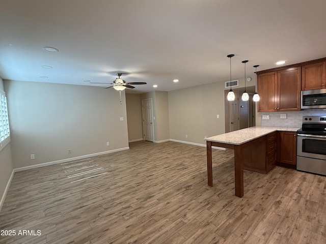 5525 E Thomas Rd Unit C2, Phoenix, AZ 85018 - kitchen featuring appliances with stainless steel finishes, recessed lighting, decorative backsplash, light wood-type flooring, and ceiling fan