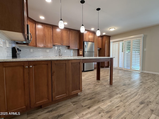 5525 E Thomas Rd Unit C2, Phoenix, AZ 85018 - kitchen featuring freestanding refrigerator, light wood-style flooring, backsplash, brown cabinetry, and recessed lighting