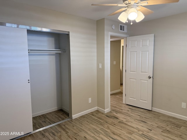 5525 E Thomas Rd Unit C2, Phoenix, AZ 85018 - unfurnished bedroom with wood finished floors, a closet, and a ceiling fan
