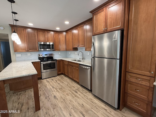 5525 E Thomas Rd Unit C2, Phoenix, AZ 85018 - kitchen featuring stainless steel appliances, light wood finished floors, tasteful backsplash, brown cabinets, and recessed lighting