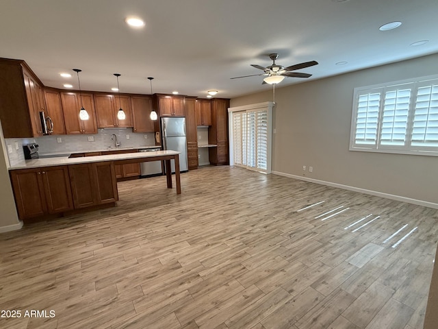 5525 E Thomas Rd Unit C2, Phoenix, AZ 85018 - kitchen with appliances with stainless steel finishes, light countertops, light wood-style floors, open floor plan, and a peninsula