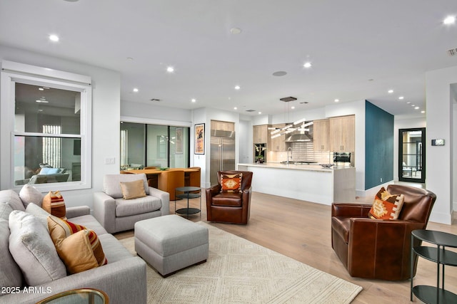 living room with sink and light hardwood / wood-style floors