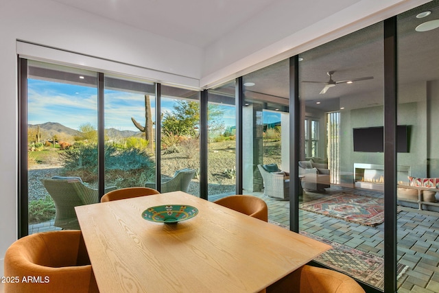 sunroom featuring a mountain view and ceiling fan