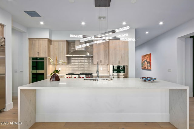 kitchen with an island with sink, sink, and double oven