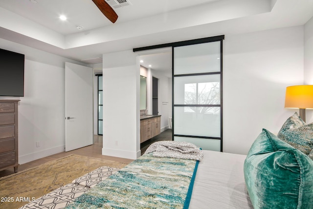 bedroom featuring connected bathroom and a raised ceiling