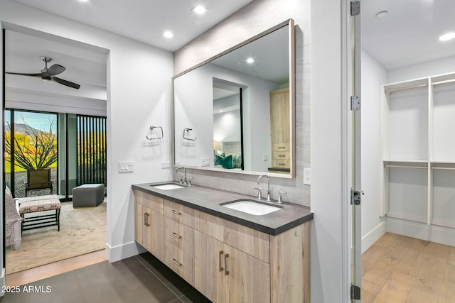 bathroom featuring ceiling fan, vanity, wood-type flooring, and backsplash