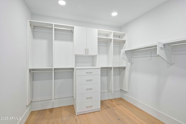 walk in closet with light hardwood / wood-style flooring