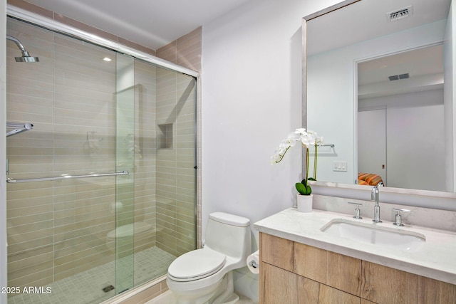 bathroom featuring vanity, toilet, and a shower with door