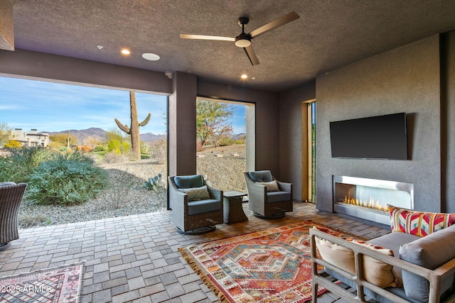 interior space with ceiling fan, a mountain view, and a textured ceiling