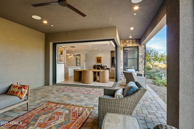 view of patio featuring an outdoor living space, sink, and ceiling fan