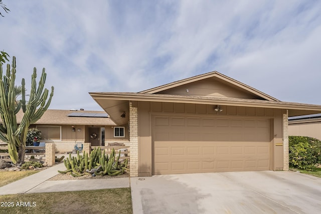 ranch-style home featuring a garage and solar panels