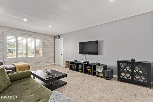 living area featuring recessed lighting, baseboards, and wooden walls