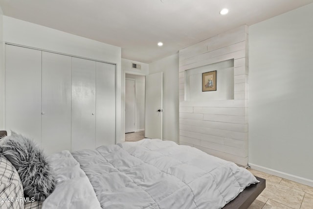 bedroom with a closet, visible vents, recessed lighting, and baseboards