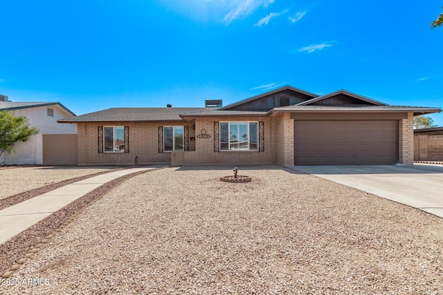 ranch-style house featuring brick siding, driveway, a garage, and fence