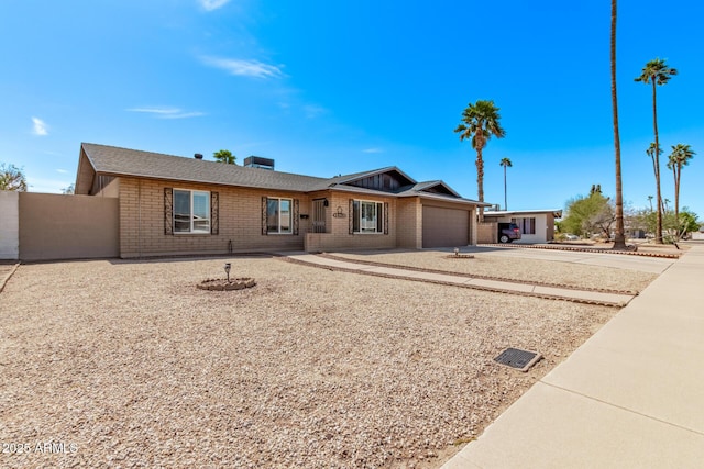 ranch-style home featuring a garage, brick siding, and driveway