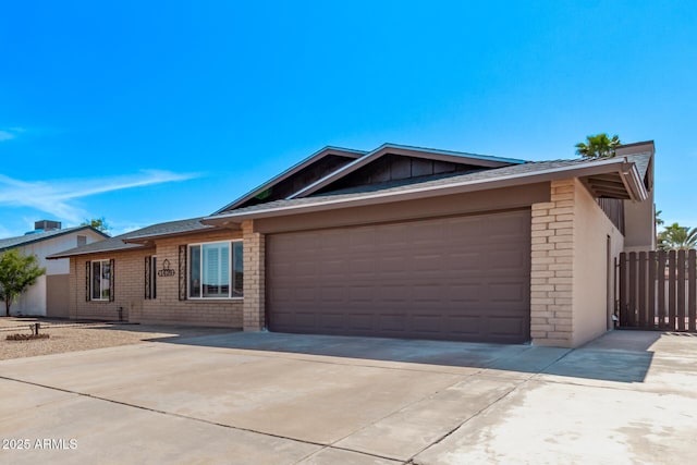 single story home featuring an attached garage, fence, brick siding, and driveway