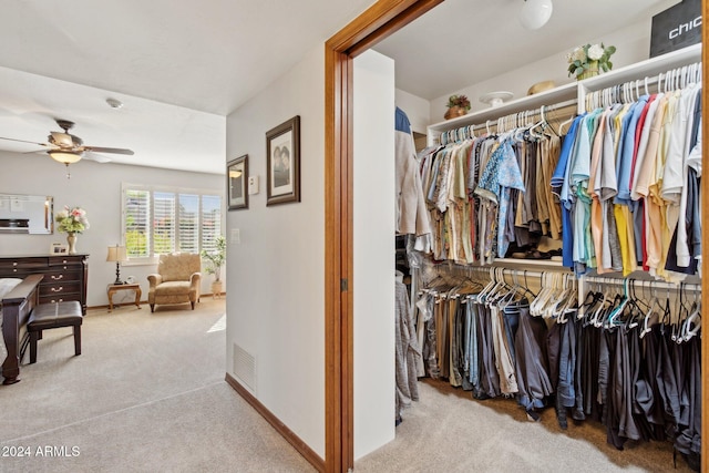 spacious closet featuring ceiling fan and light colored carpet