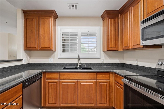 kitchen featuring a sink, brown cabinets, visible vents, and stainless steel appliances