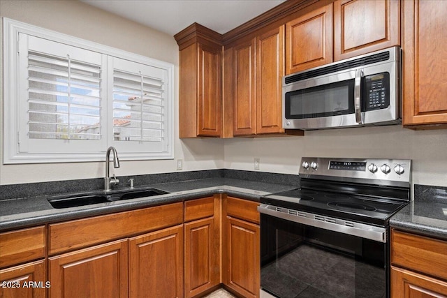 kitchen with brown cabinetry, stainless steel appliances, and a sink