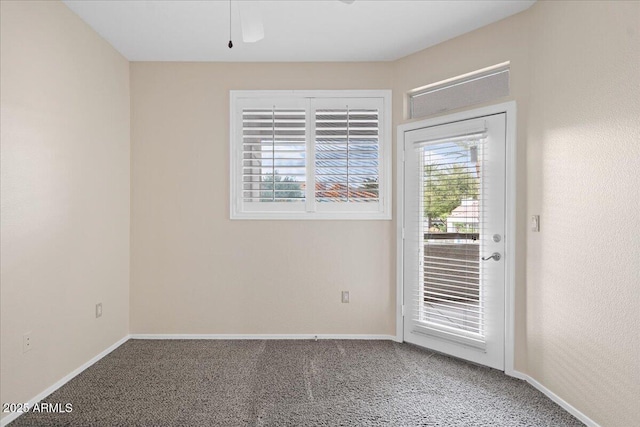 carpeted spare room featuring baseboards