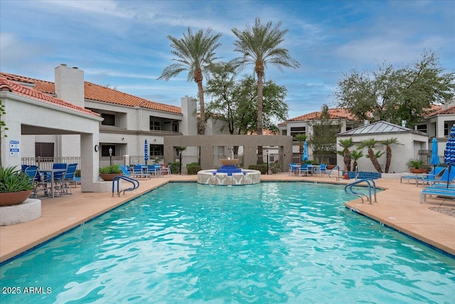 pool with a patio and fence