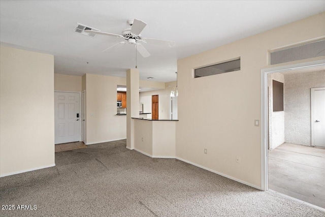 unfurnished living room with baseboards, visible vents, carpet floors, and ceiling fan