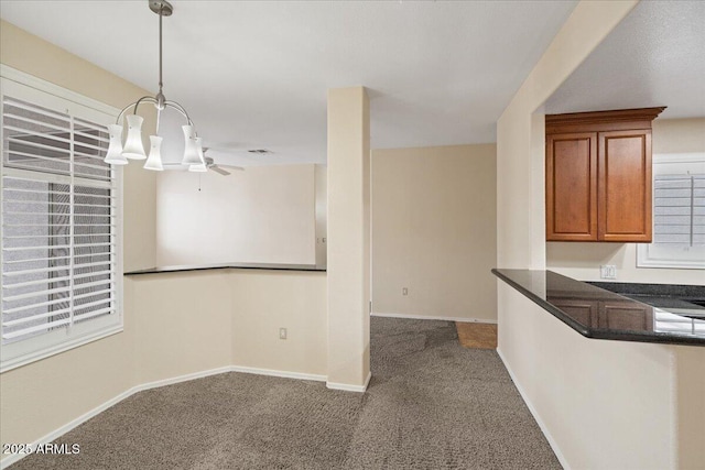 unfurnished dining area featuring carpet flooring, a ceiling fan, and baseboards