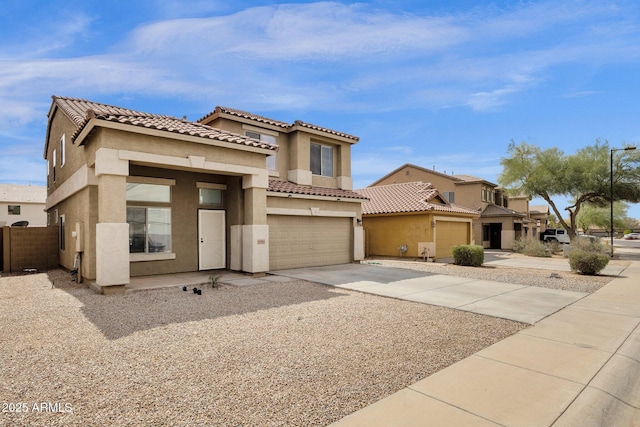 mediterranean / spanish house featuring stucco siding, concrete driveway, an attached garage, and a tiled roof