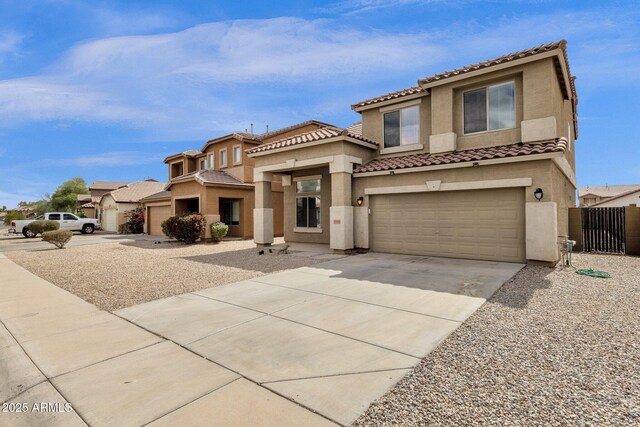 mediterranean / spanish-style home featuring fence, a garage, driveway, and stucco siding