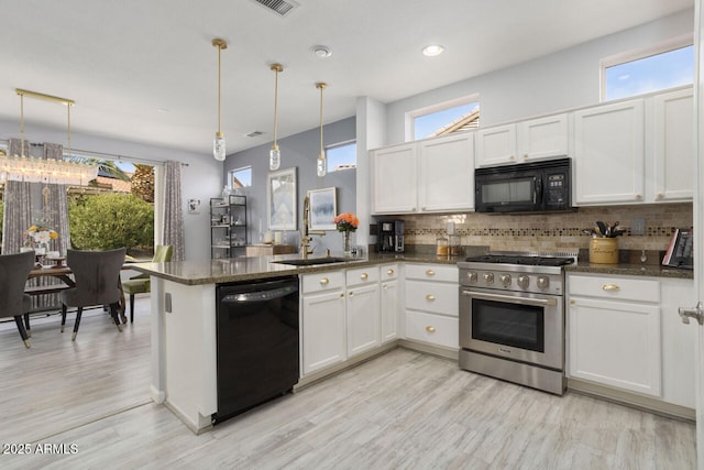 kitchen with white cabinetry, sink, hanging light fixtures, and black appliances