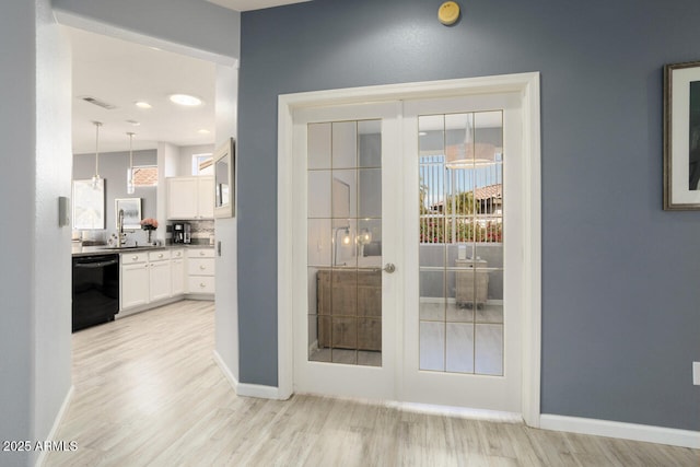 entryway featuring french doors, sink, and light hardwood / wood-style flooring