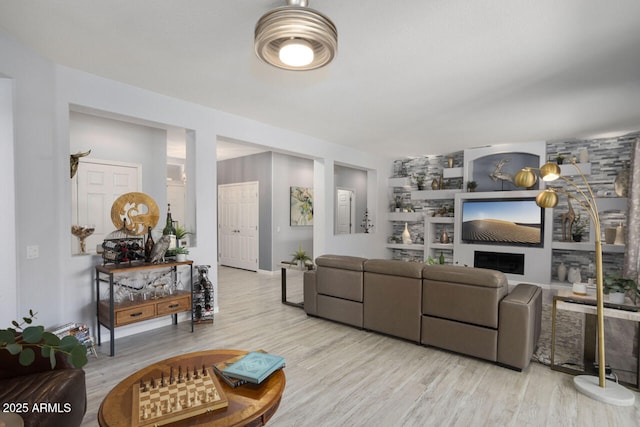 living room with a fireplace and light wood-type flooring