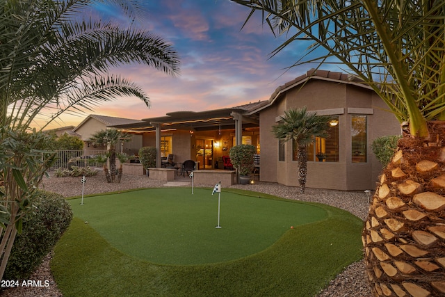 back house at dusk featuring a patio area