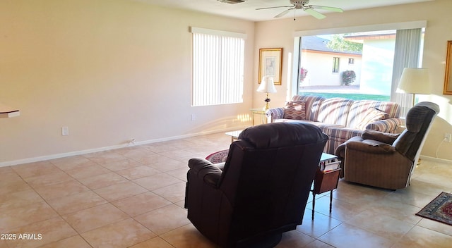 living area with light tile patterned floors, visible vents, a ceiling fan, and baseboards