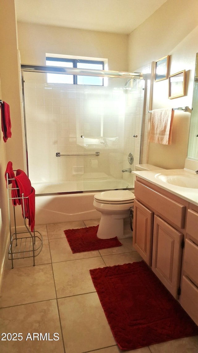 bathroom with bath / shower combo with glass door, vanity, toilet, and tile patterned floors