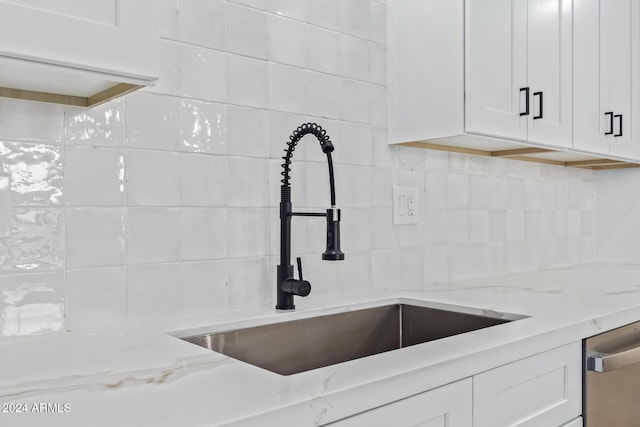 interior details featuring decorative backsplash, light stone counters, and sink