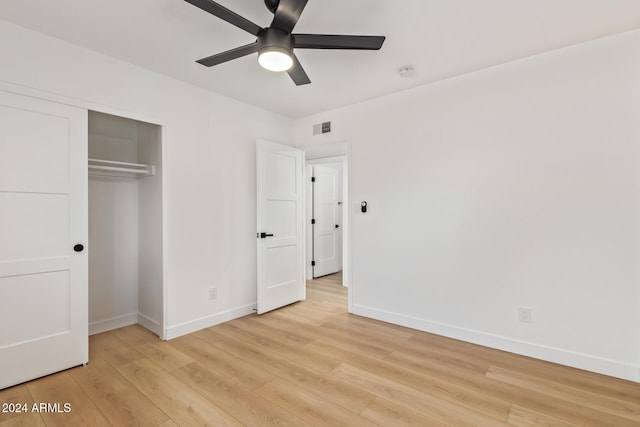 unfurnished bedroom featuring ceiling fan, light wood-type flooring, and a closet