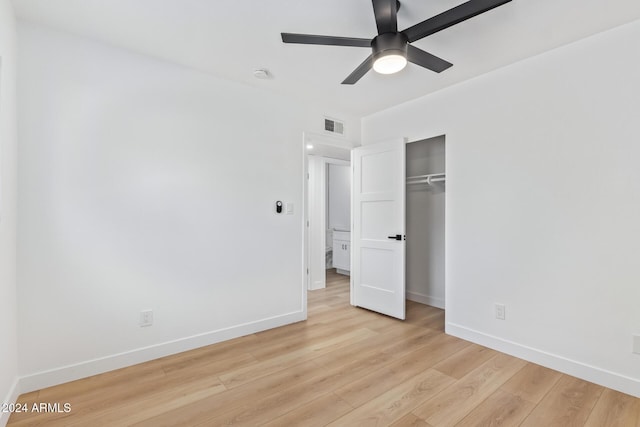 unfurnished bedroom with ceiling fan, light wood-type flooring, and a closet