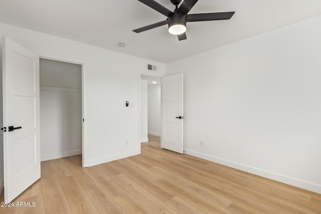 unfurnished bedroom with a closet, light hardwood / wood-style flooring, and ceiling fan