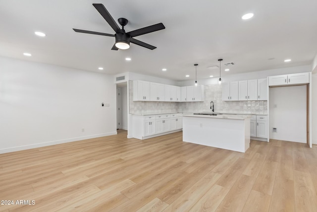 kitchen with white cabinetry, a kitchen island, and light hardwood / wood-style floors