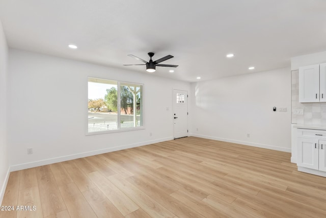 unfurnished living room featuring ceiling fan and light hardwood / wood-style flooring