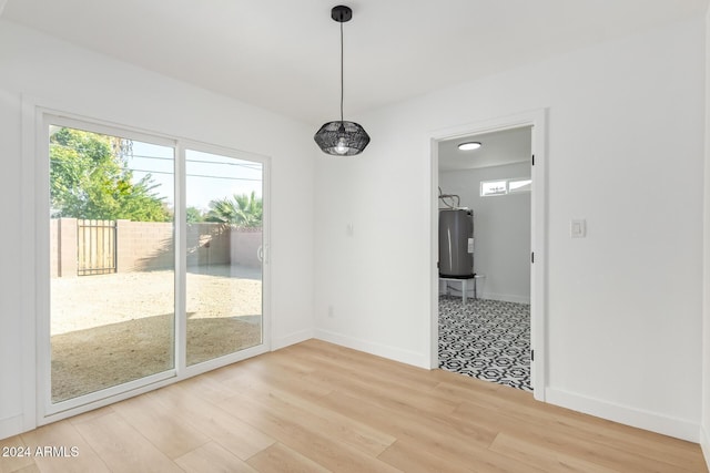 unfurnished dining area with wood-type flooring and water heater