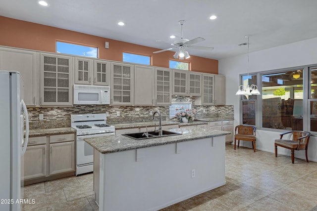 11413 S Coolwater Dr, Goodyear, AZ 85338 - kitchen with a center island with sink, a sink, white appliances, decorative backsplash, and ceiling fan